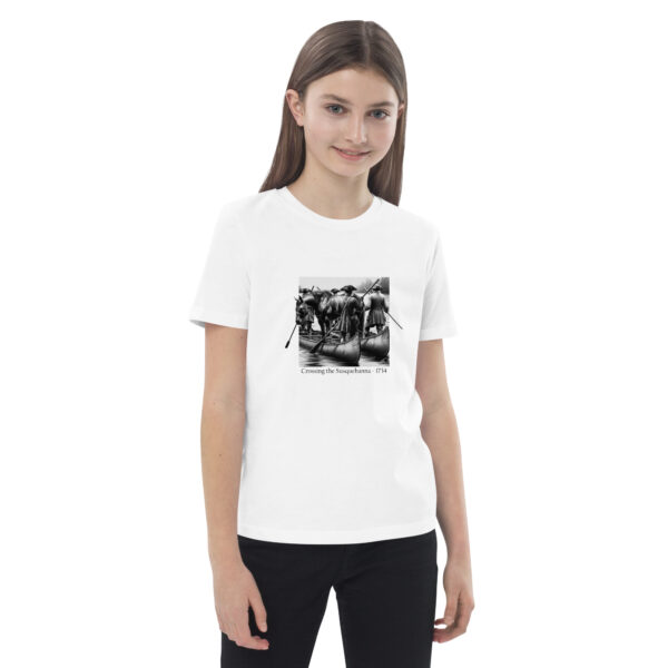 organic cotton kids t shirt white front with image depicting Ellis Lewis crossing the Susquehanna River in 1734. A hobbled and blindfolded horse stands astride two canoes, guided by four Quakers paddling as found in ‘The History of Silver Lake” on the historyofsilverlake.com website.