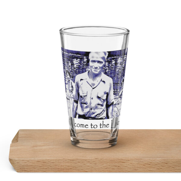 shaker pint glass 16 oz 16 oz front with image of the book cover for 'The History of Silver Lake as Told Through Its Deeds' showing, Pappy, in foreground from the "Great Book! No Cicadas!" billboard, two young women in a canoe behind him, and a young girl peeking from behind a tree saying ‘Welcome to the Lake’ on the historyofsilverlake.com website.