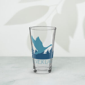 shaker pint glass 16 oz 16 oz front with a stylized teal blue logo for 'History of Silver Lake' book: A single goose flying over Silver Lake with trees in the background.