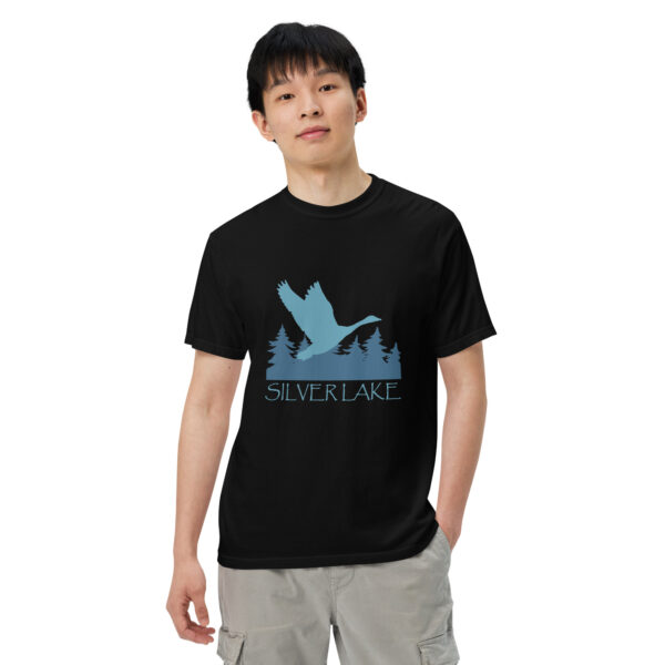 unisex garment dyed heavyweight t shirt black front 2 with a stylized teal blue logo for 'History of Silver Lake' book: A single goose flying over Silver Lake with trees in the background.