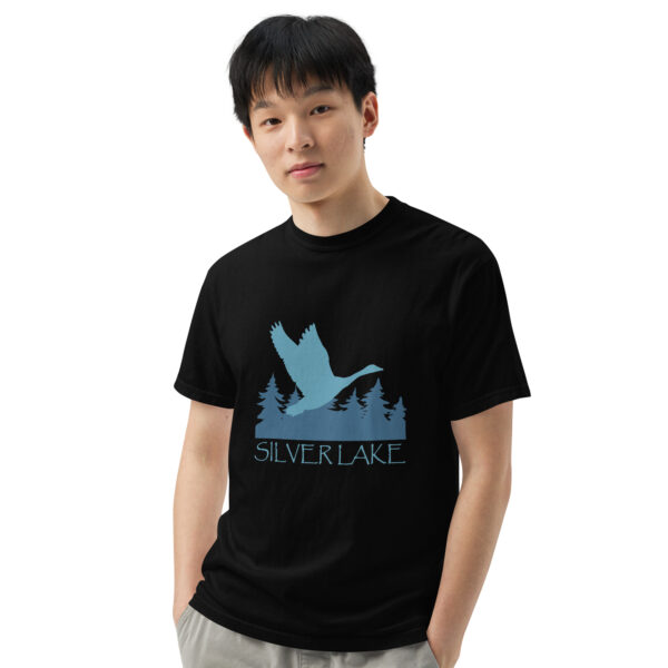 unisex garment dyed heavyweight t shirt black front 3 with a stylized teal blue logo for 'History of Silver Lake' book: A single goose flying over Silver Lake with trees in the background.