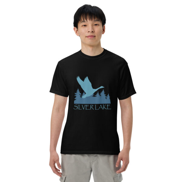 unisex garment dyed heavyweight t shirt black front with a stylized teal blue logo for 'History of Silver Lake' book: A single goose flying over Silver Lake with trees in the background.