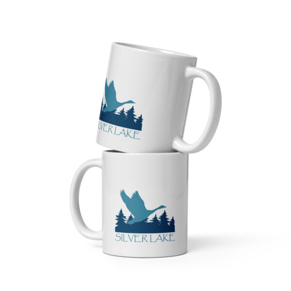 white glossy mug white 11 oz front view with a stylized teal blue logo for 'History of Silver Lake' book: A single goose flying over Silver Lake with trees in the background.