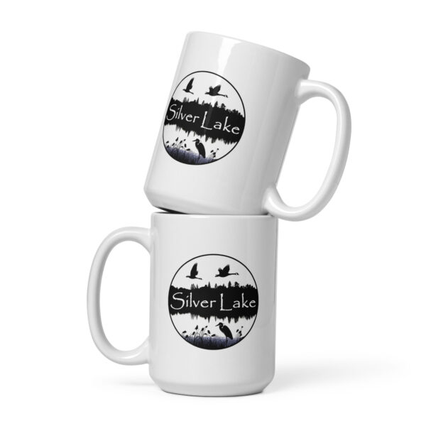 white glossy mug white 15 oz front view with a circular image of Silver Lake with a blue heron in the foreground and Canadian Geese flying over the lake taken from "The History of Silver Lake as Told Through Its Deeds".