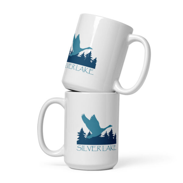 white glossy mug white 15 oz front view with a stylized teal blue logo for 'History of Silver Lake' book: A single goose flying over Silver Lake with trees in the background.