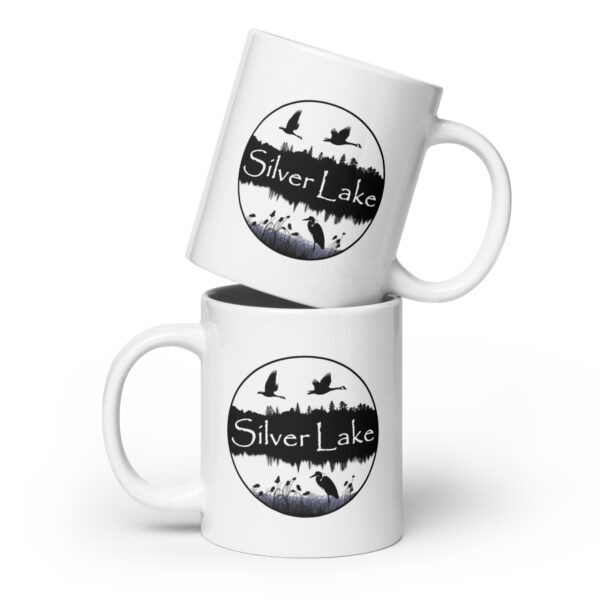 white glossy mug white 20 oz front view with a circular image of Silver Lake with a blue heron in the foreground and Canadian Geese flying over the lake taken from "The History of Silver Lake as Told Through Its Deeds".